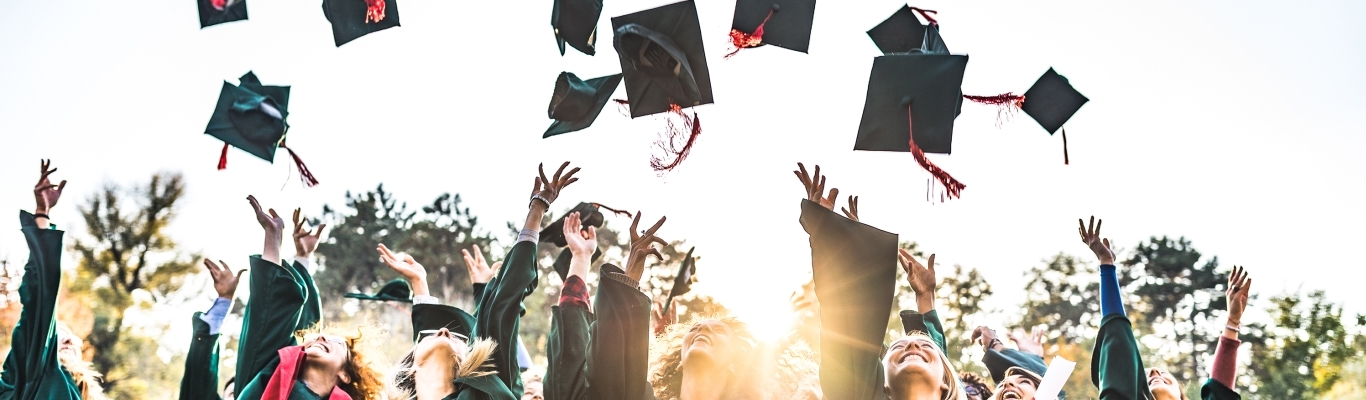 Recent Grads Tossing Graduation Hats